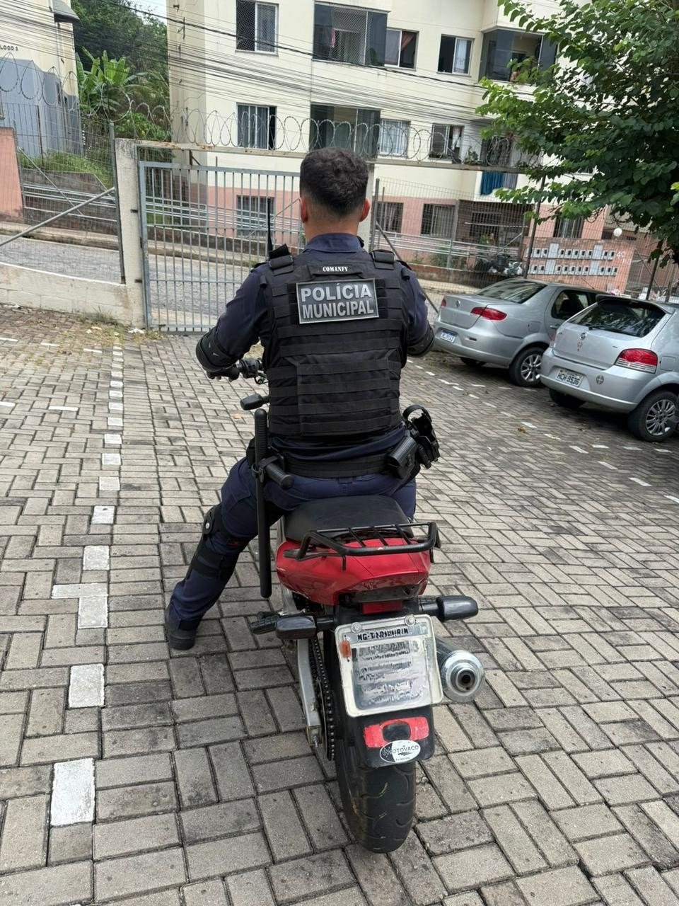 Policial municipal sobre a motocicleta recuperada, em Ipatinga
